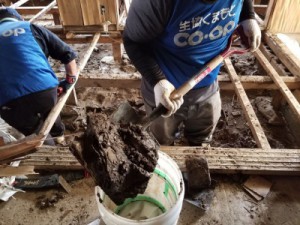 床下の泥を土嚢に詰める作業